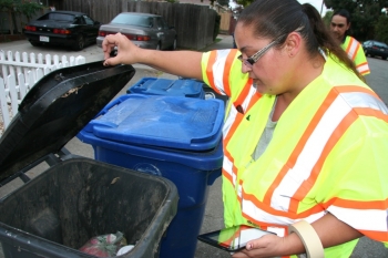 worker looking in garbage bin
